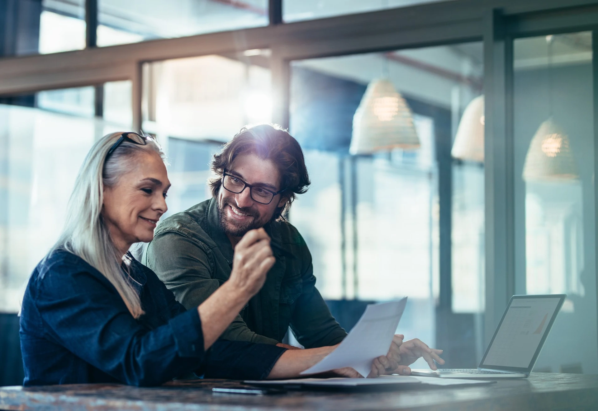 Male Tenant Representative and Female Client Sitting at a Desk Looking Over a Real Estate Document